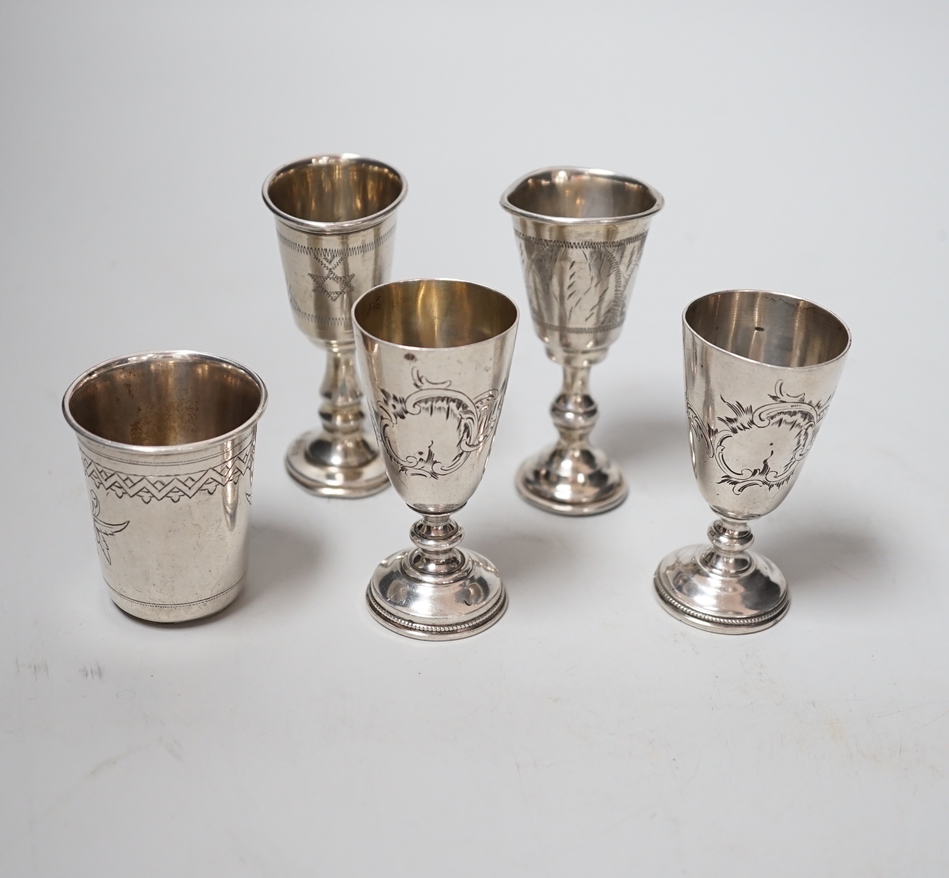 Two George V silver kiddush cups, 82mm, two Russian 84 zolotnik white metal pedestal tots and similar beaker, dated 1890, 4.6oz.
